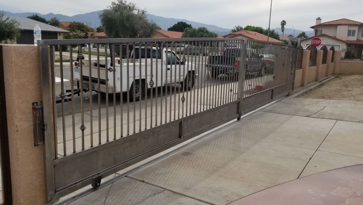 A white truck is parked behind a sliding gate.