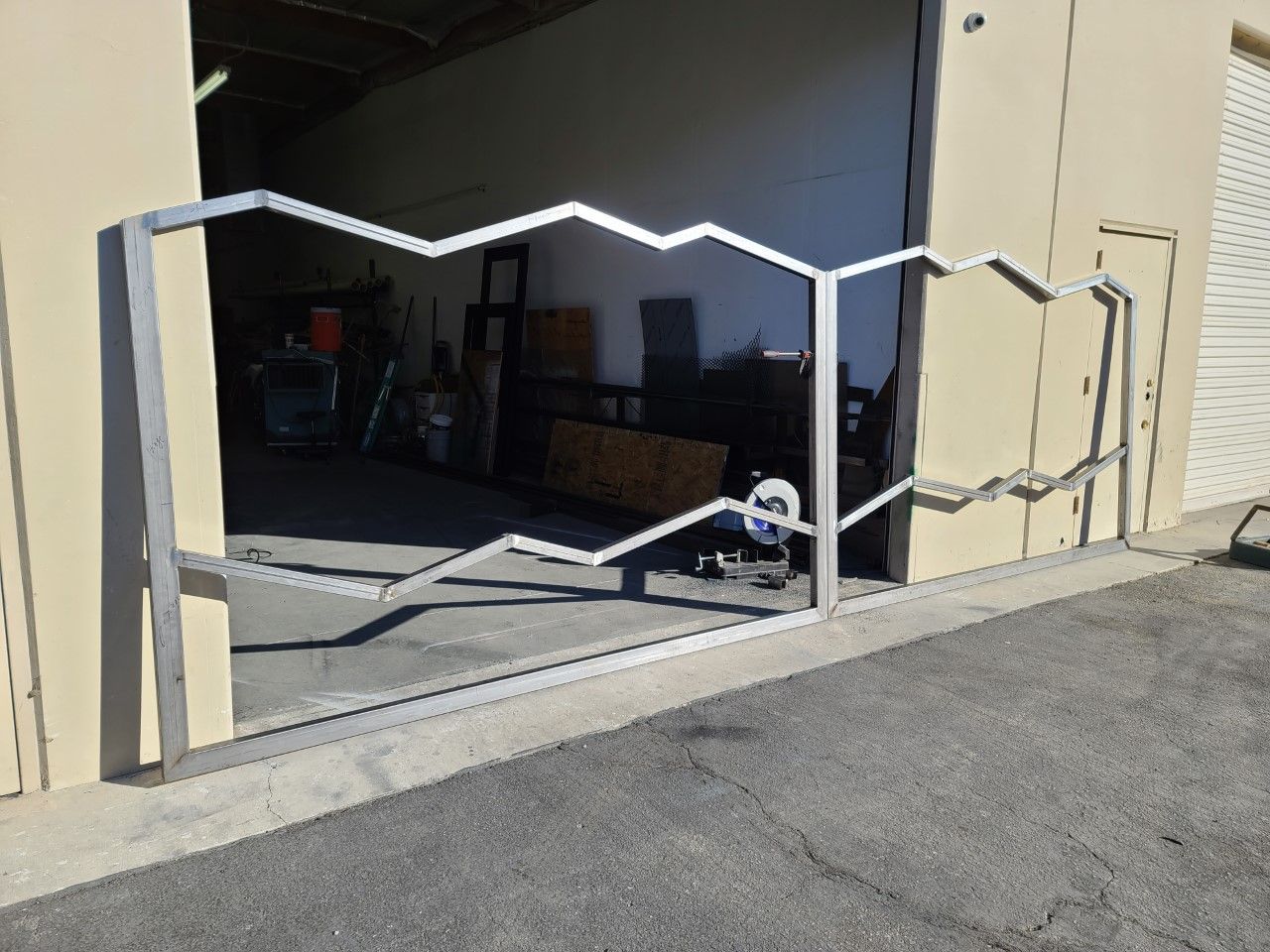 A metal gate that looks like mountains is in front of a building