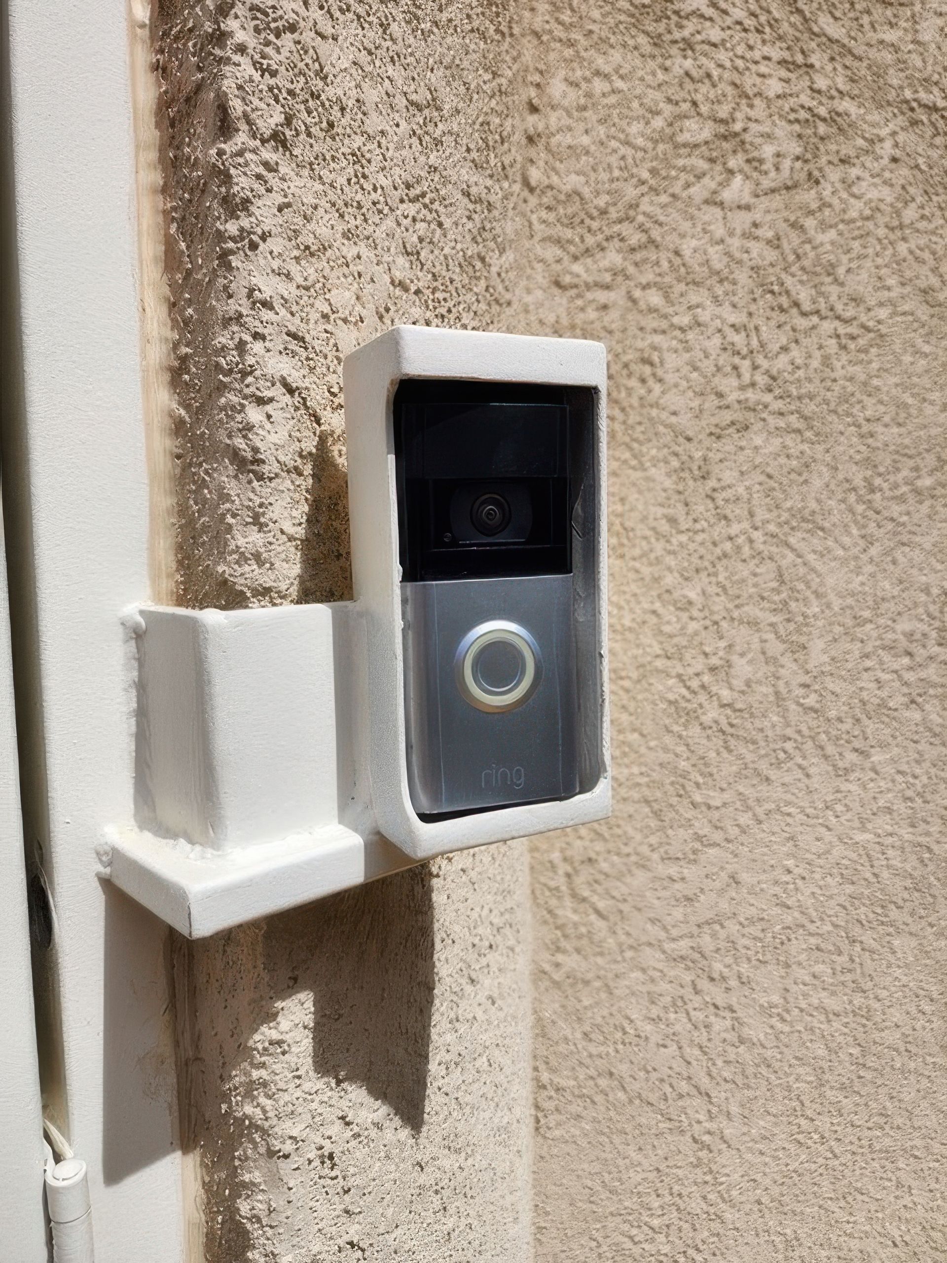A ring doorbell is mounted on the side of a building.