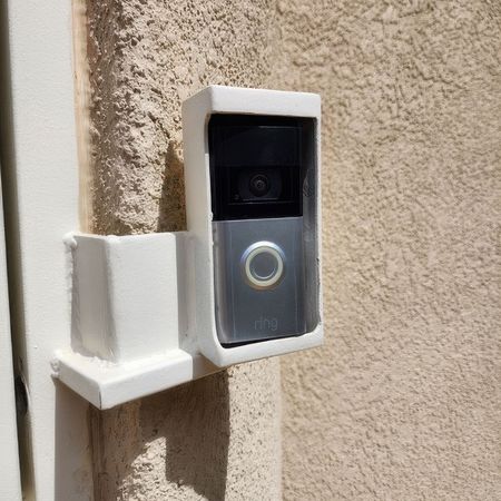 A ring doorbell is mounted on the side of a building.