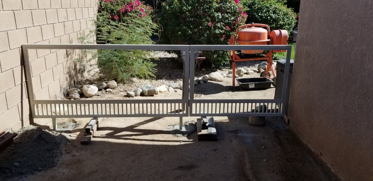 A sliding gate is sitting in front of a brick wall.