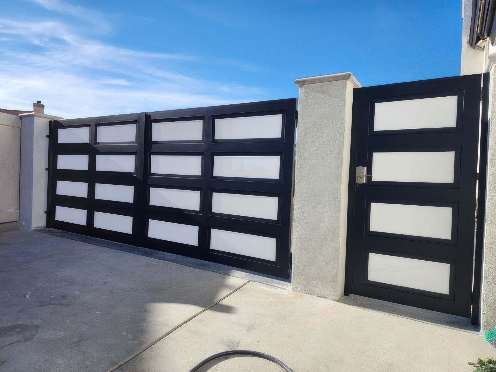A black and white gate with a blue sky in the background