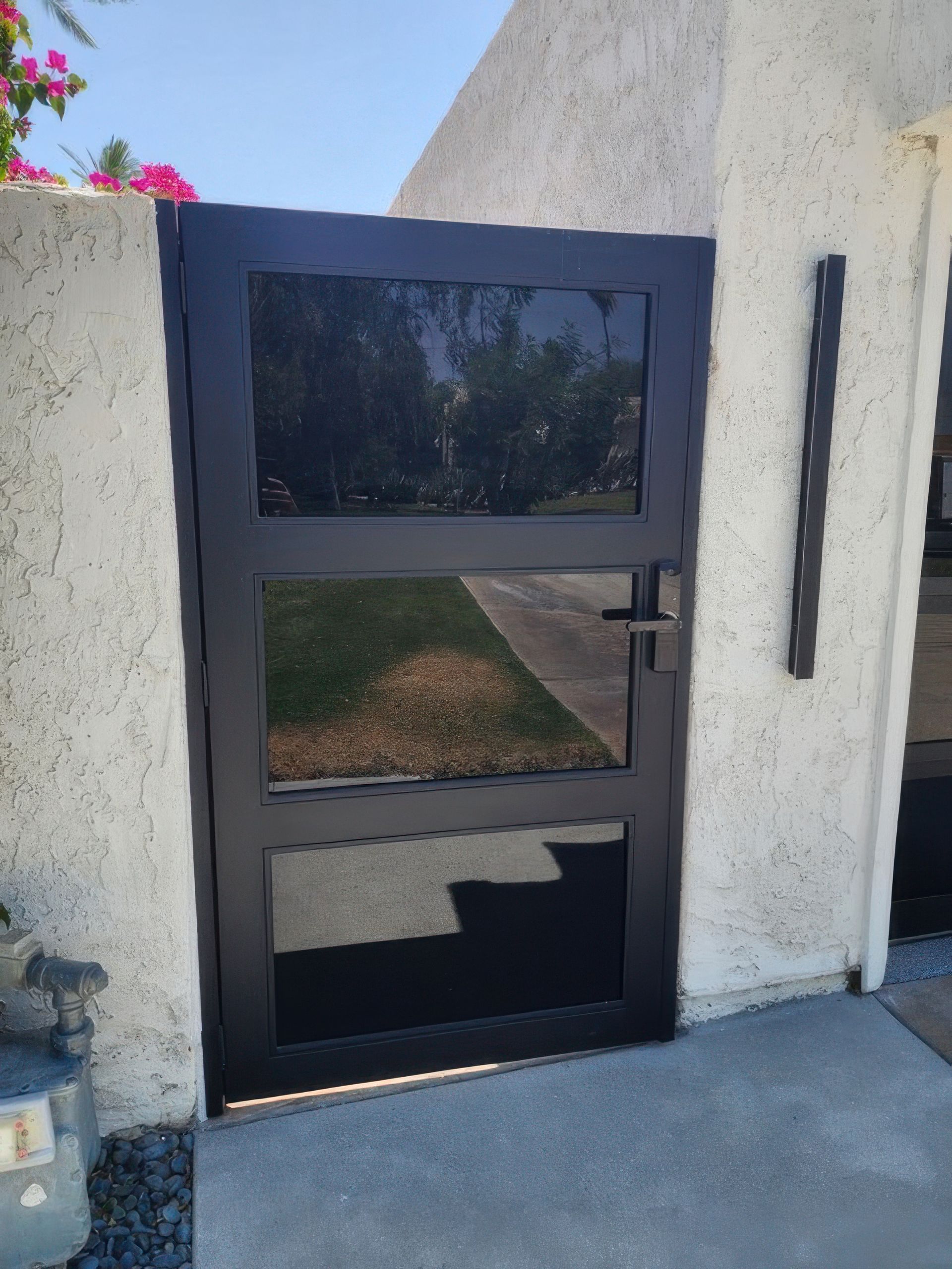 A black gate with a reflection of trees in it