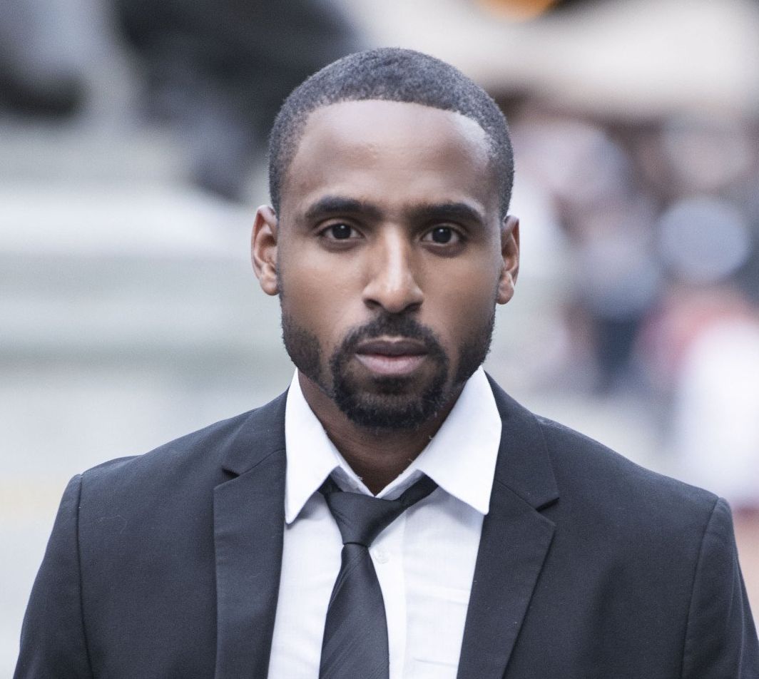 A man with a beard is wearing a suit and tie