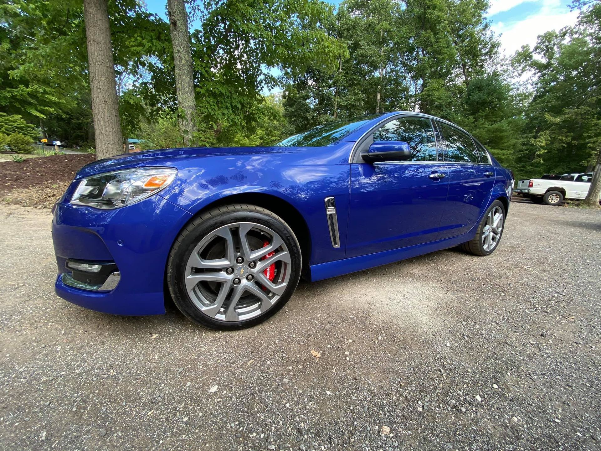 Blue Chevrolet SS sedan parked on gravel.
