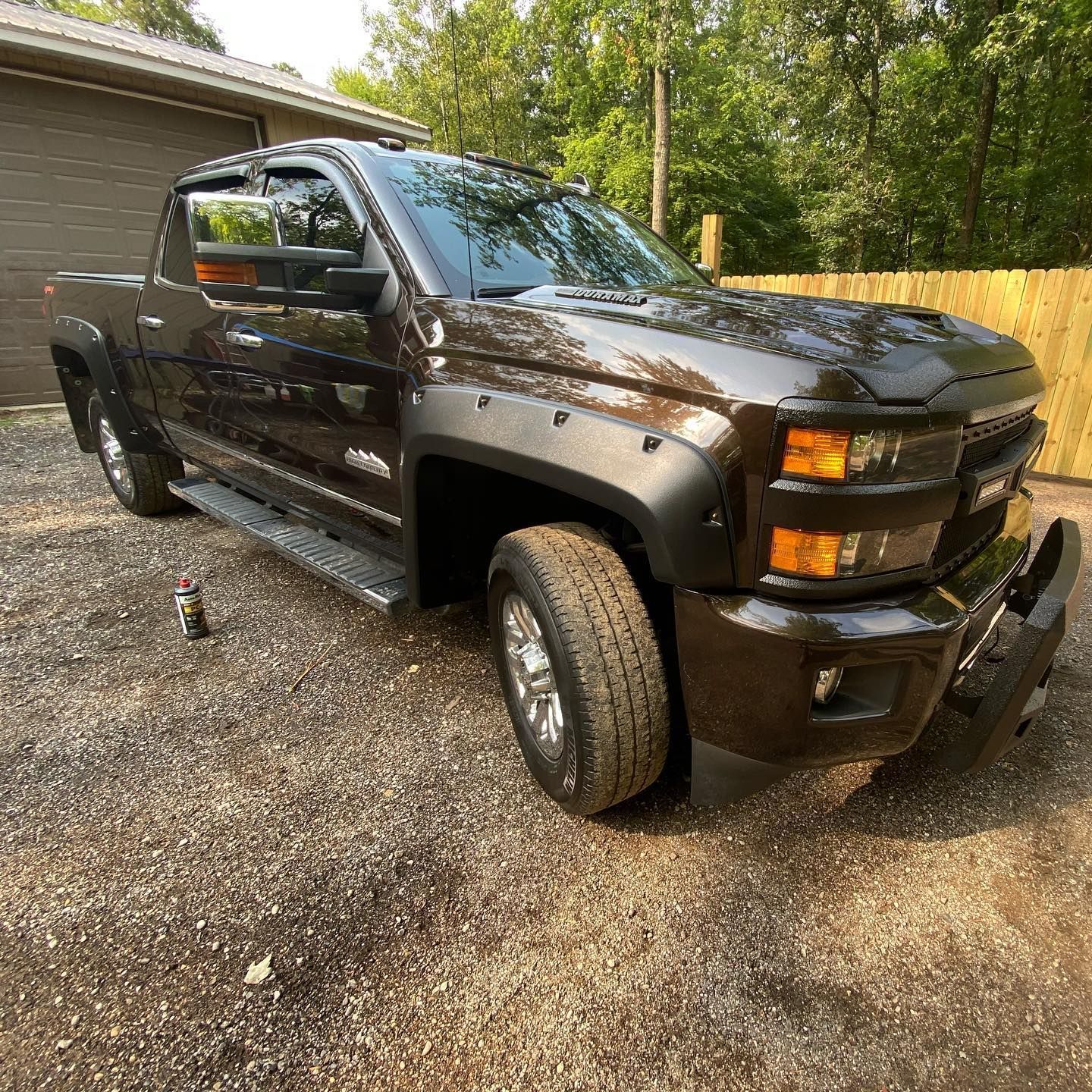 Dark brown Chevrolet pickup truck parked on gravel.