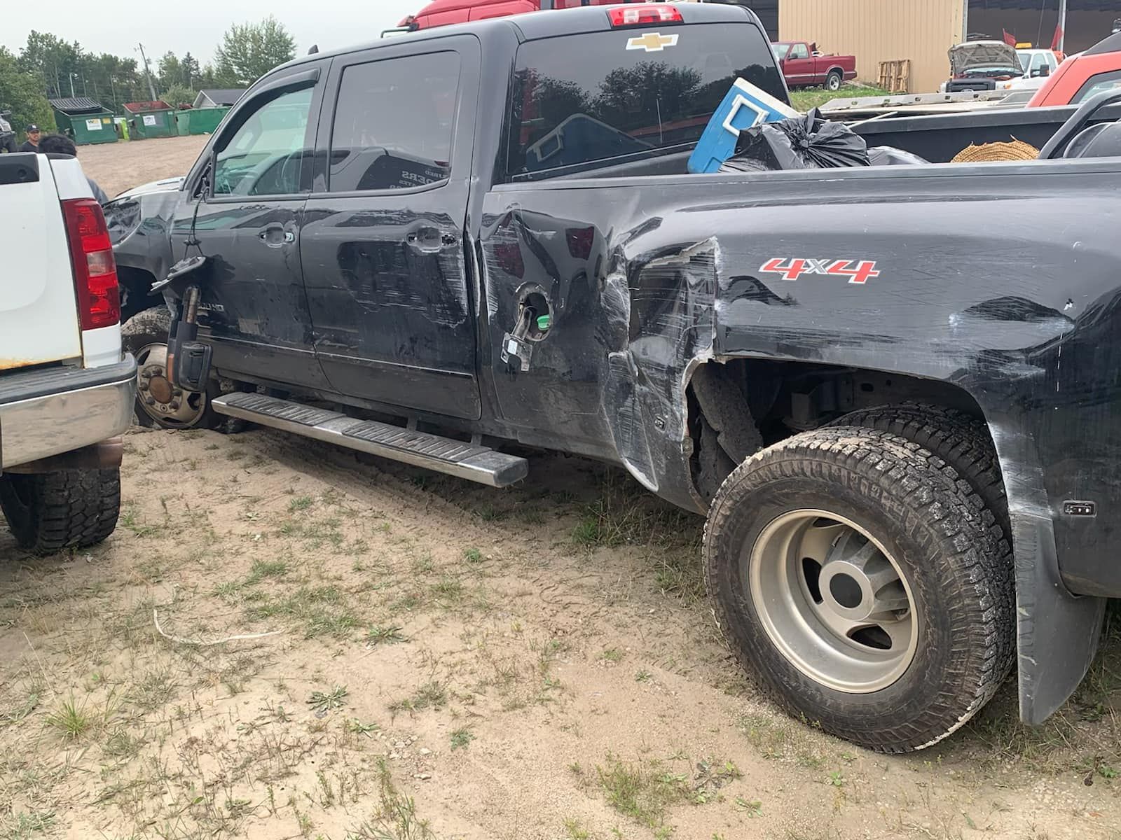 Black Chevrolet pickup truck heavily damaged on side and rear. 