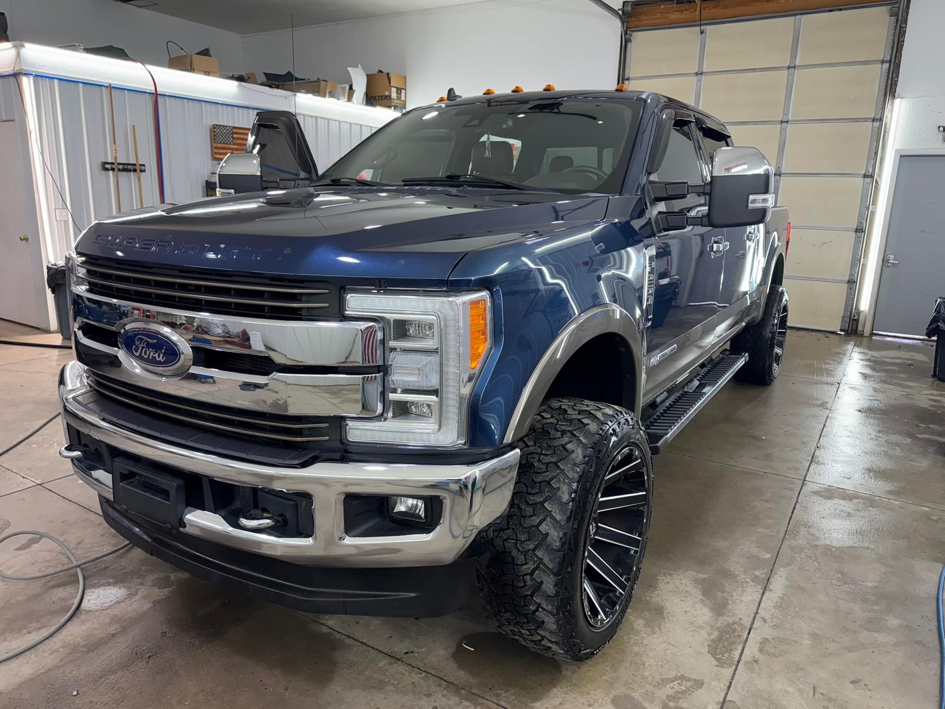 Blue Ford truck with chrome accents parked inside a garage.