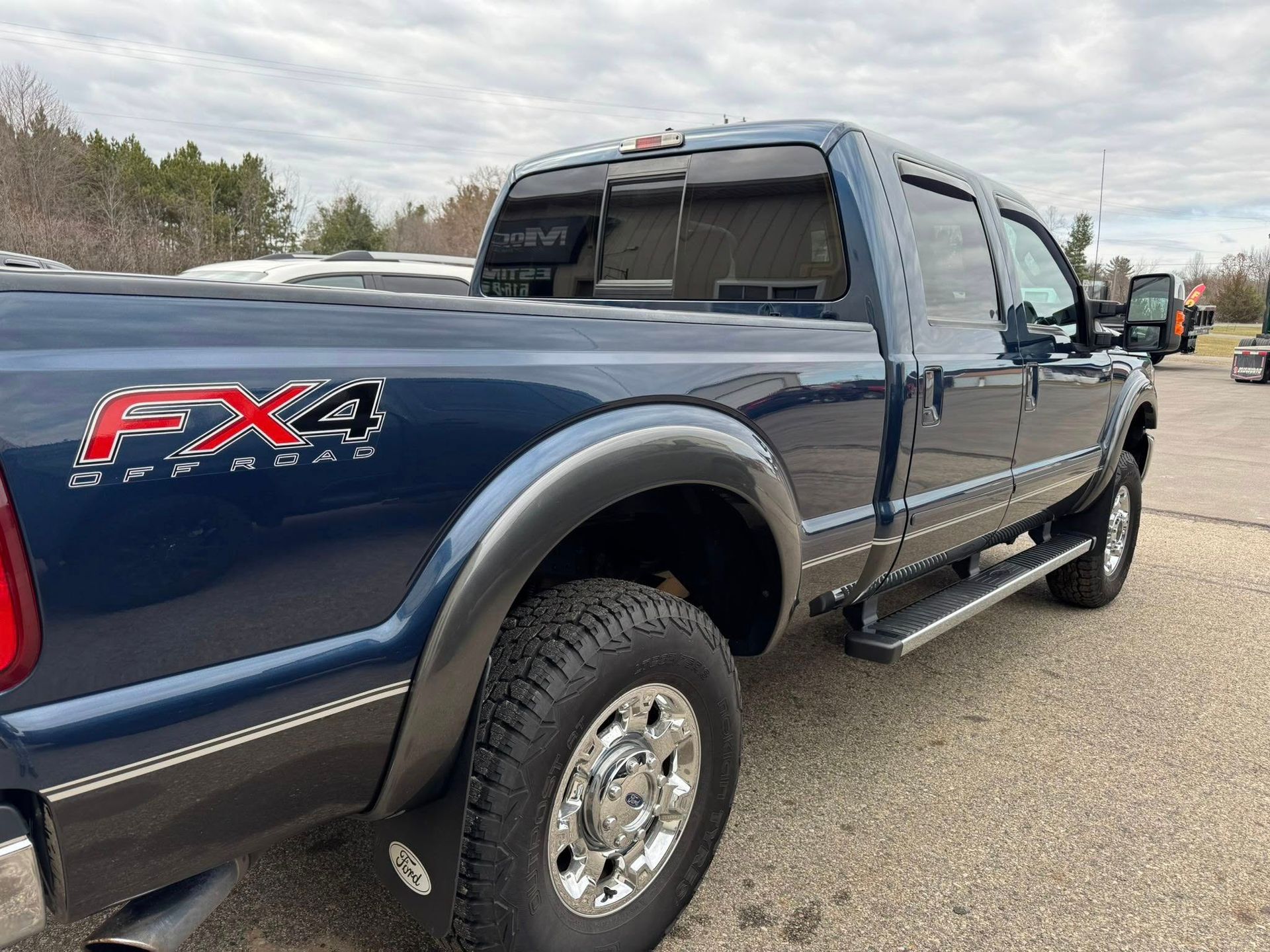 Dark blue Ford F-250 pickup truck with FX4 Off-Road sticker and chrome wheels.