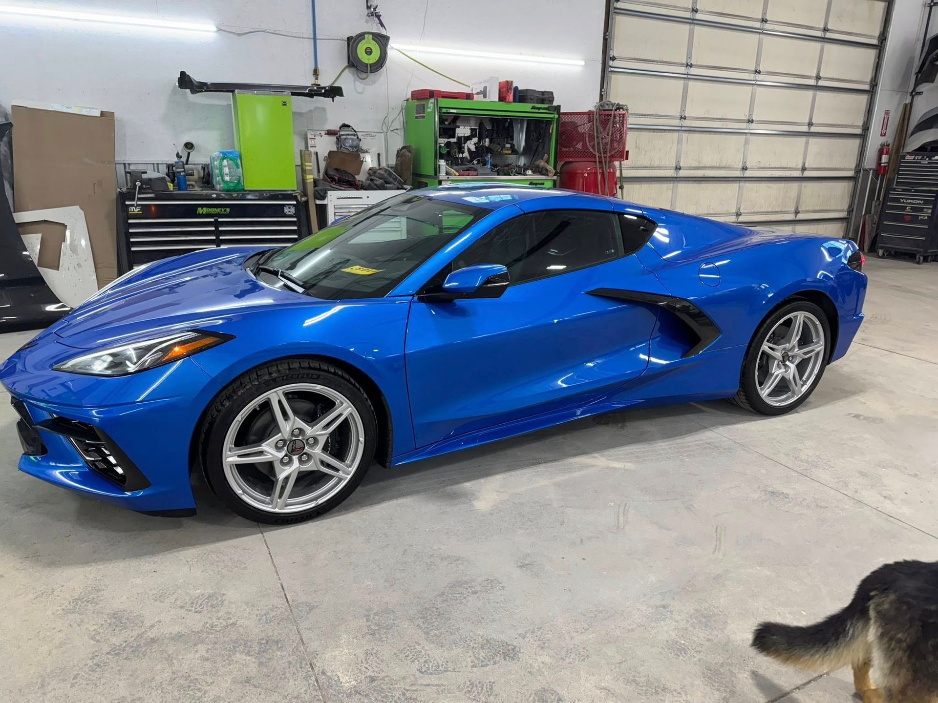 Blue Chevrolet Corvette sports car in a garage.