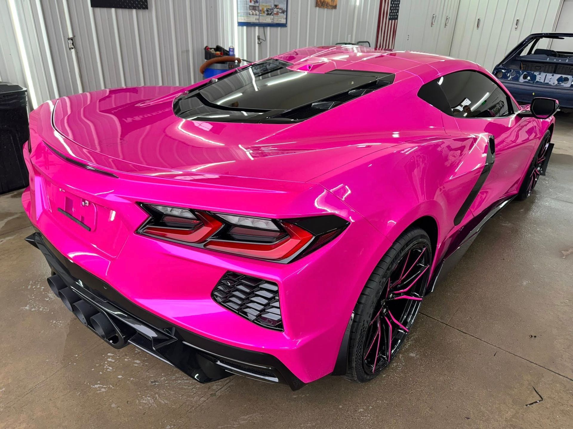 Bright pink Corvette sports car in a garage.