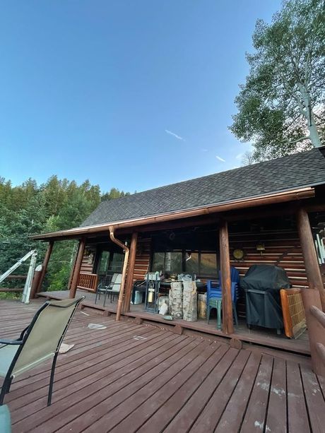 Finished roofing and gutter project on log cabin deck