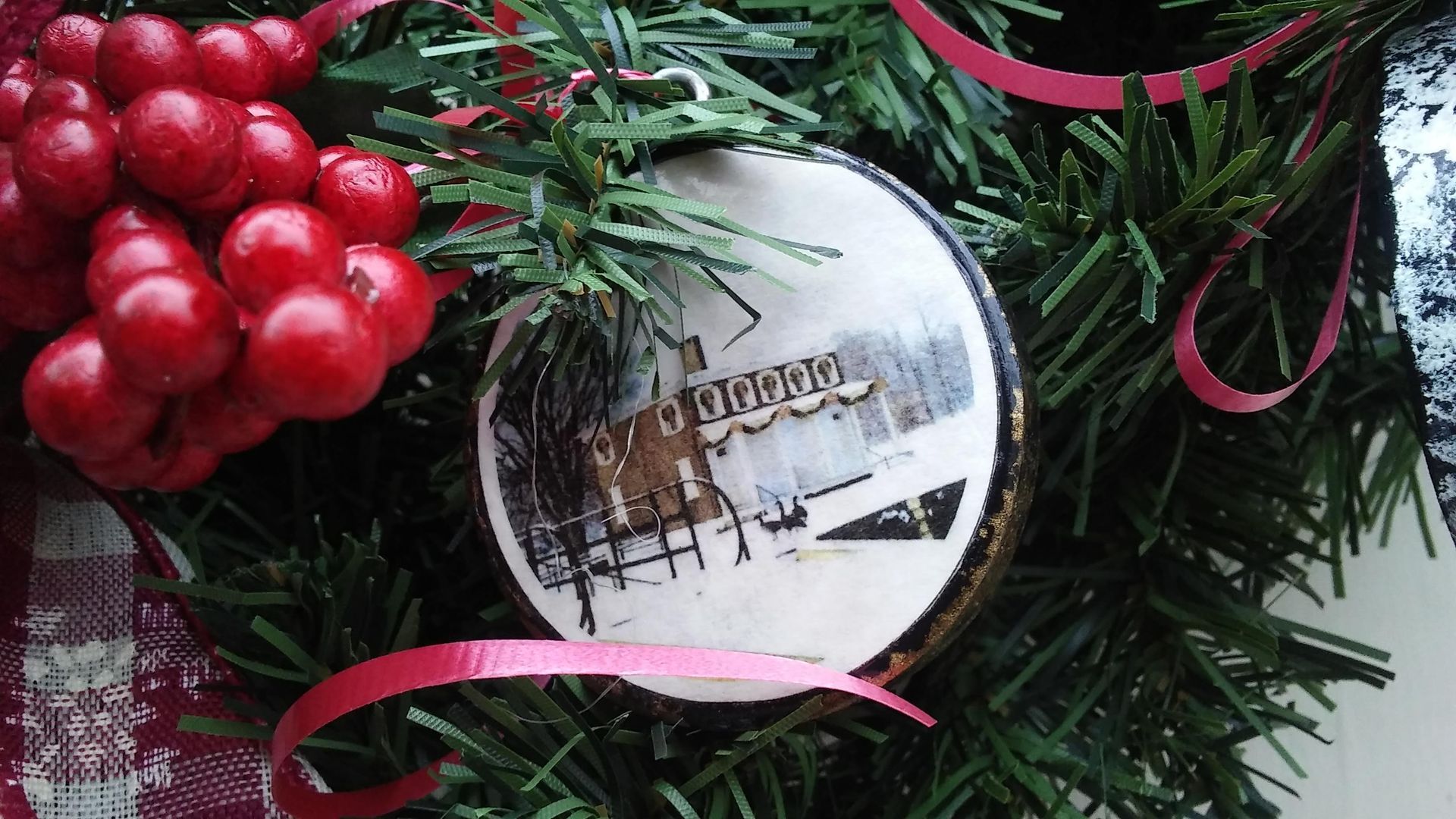 53 rd Candlelight Tour: white house with two candles, pine cones, evergreen.