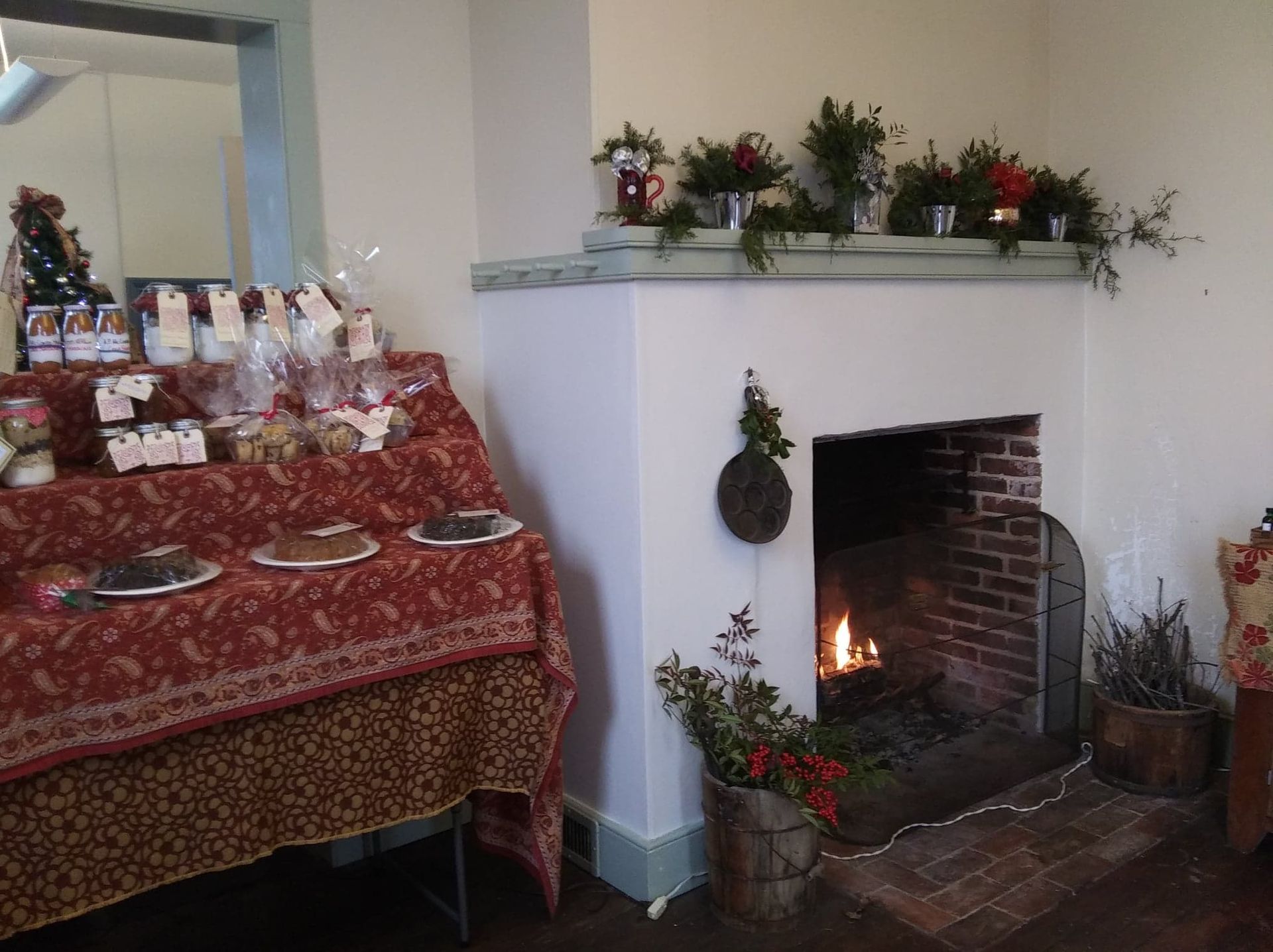 Fireplace with burning fire, baked goods displayed, decorated for the holidays.