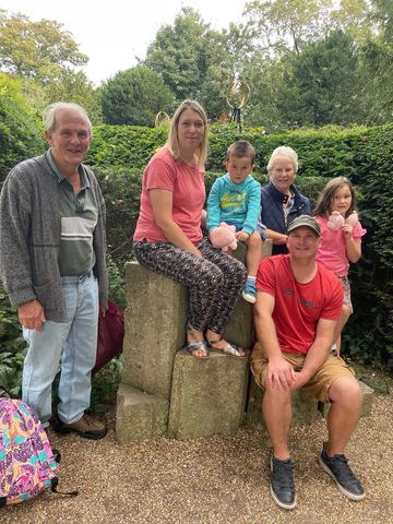 A group of people are posing for a picture in a park.