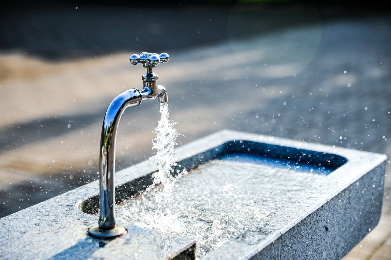 tap water coming out of a silver faucet