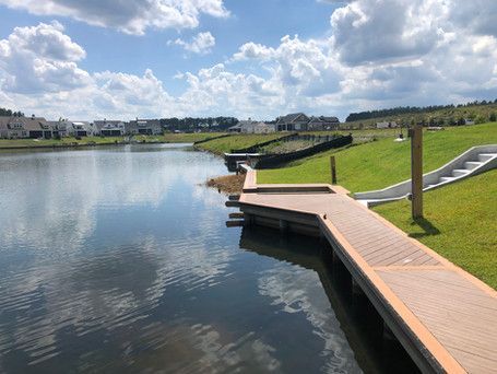 A wooden dock is sitting next to a body of water.