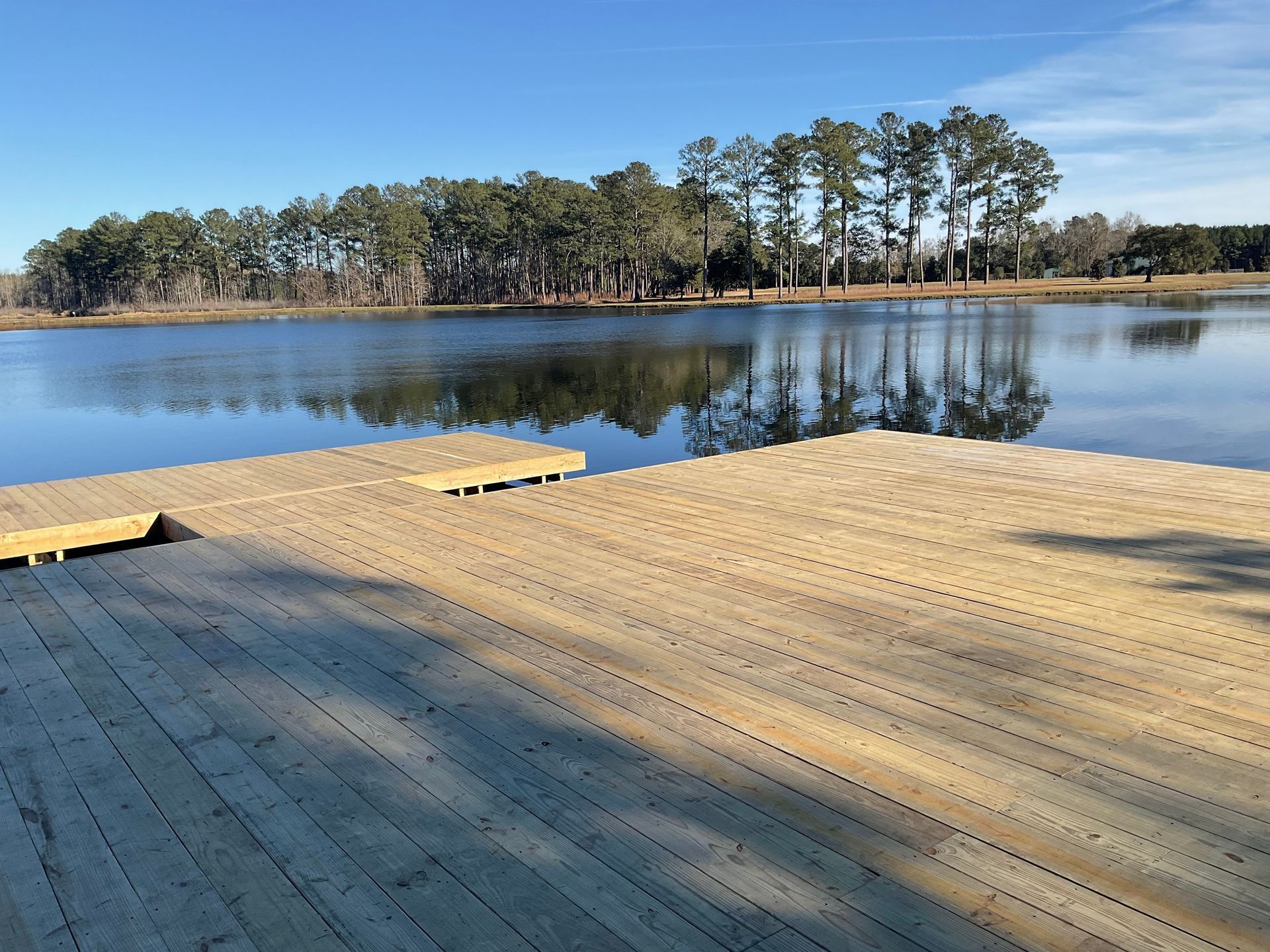 A wooden dock overlooking a lake with trees in the background