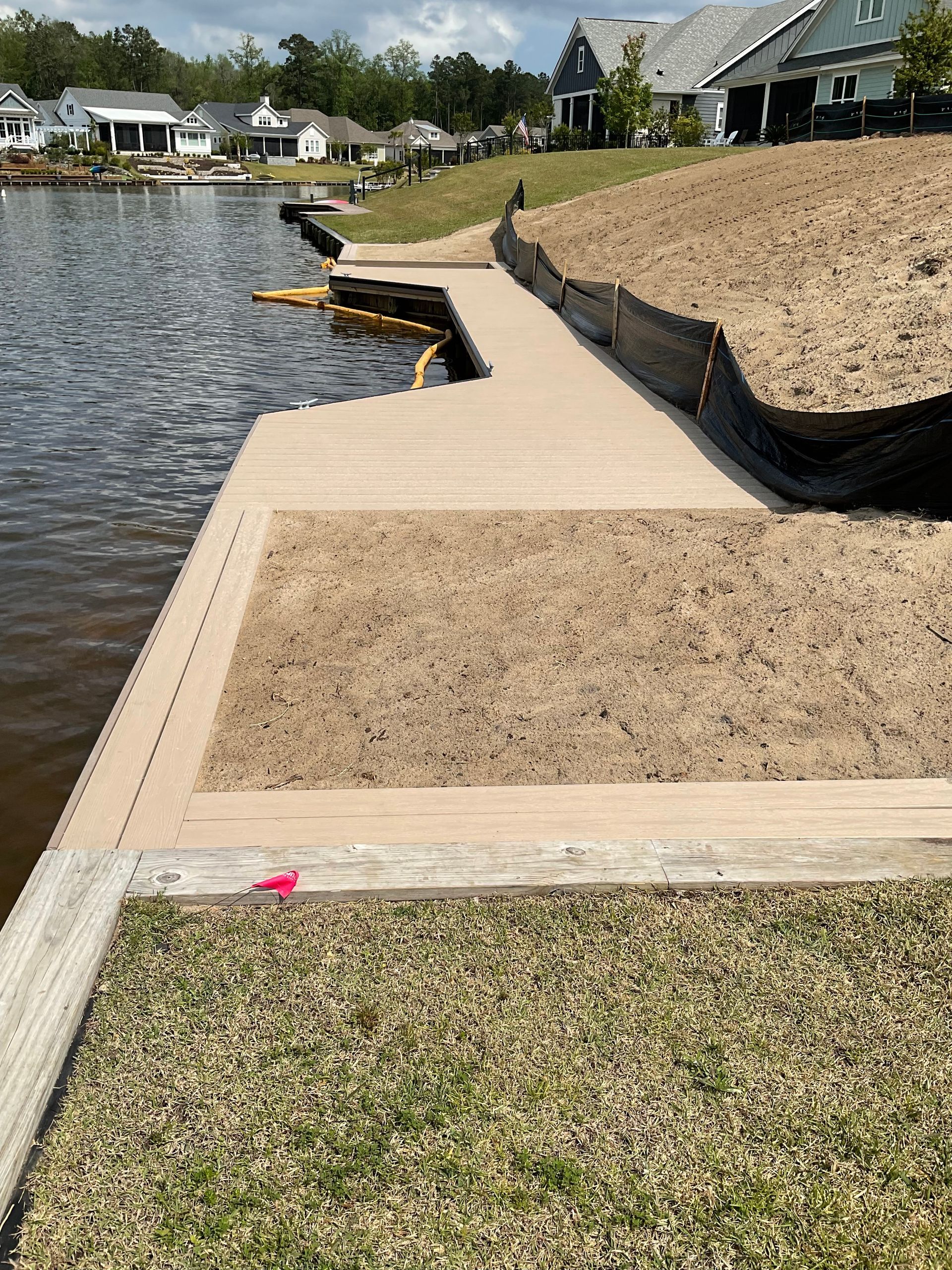 A wooden dock is sitting next to a body of water.
