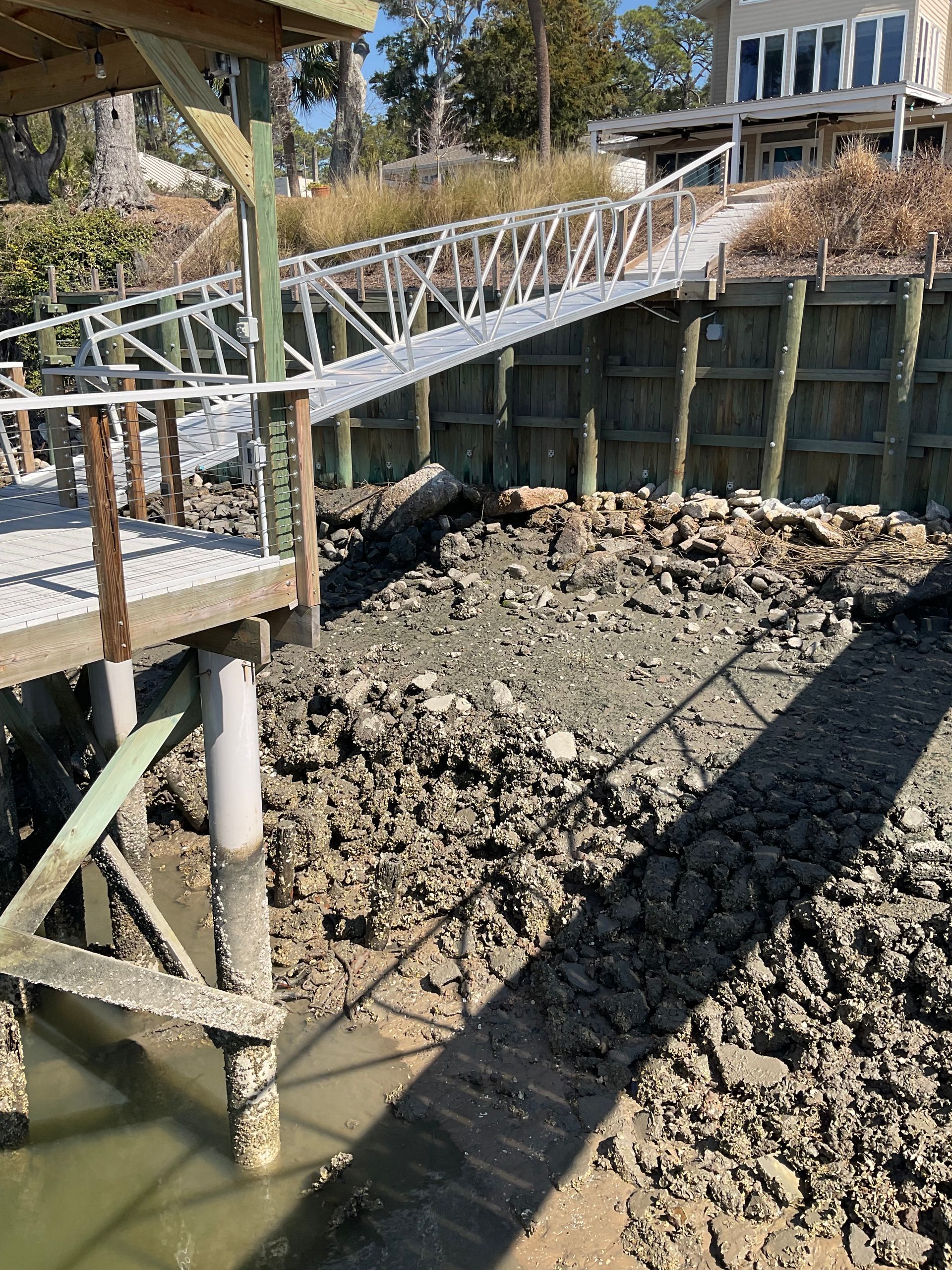 A wooden dock leading to a lake with trees in the background.
