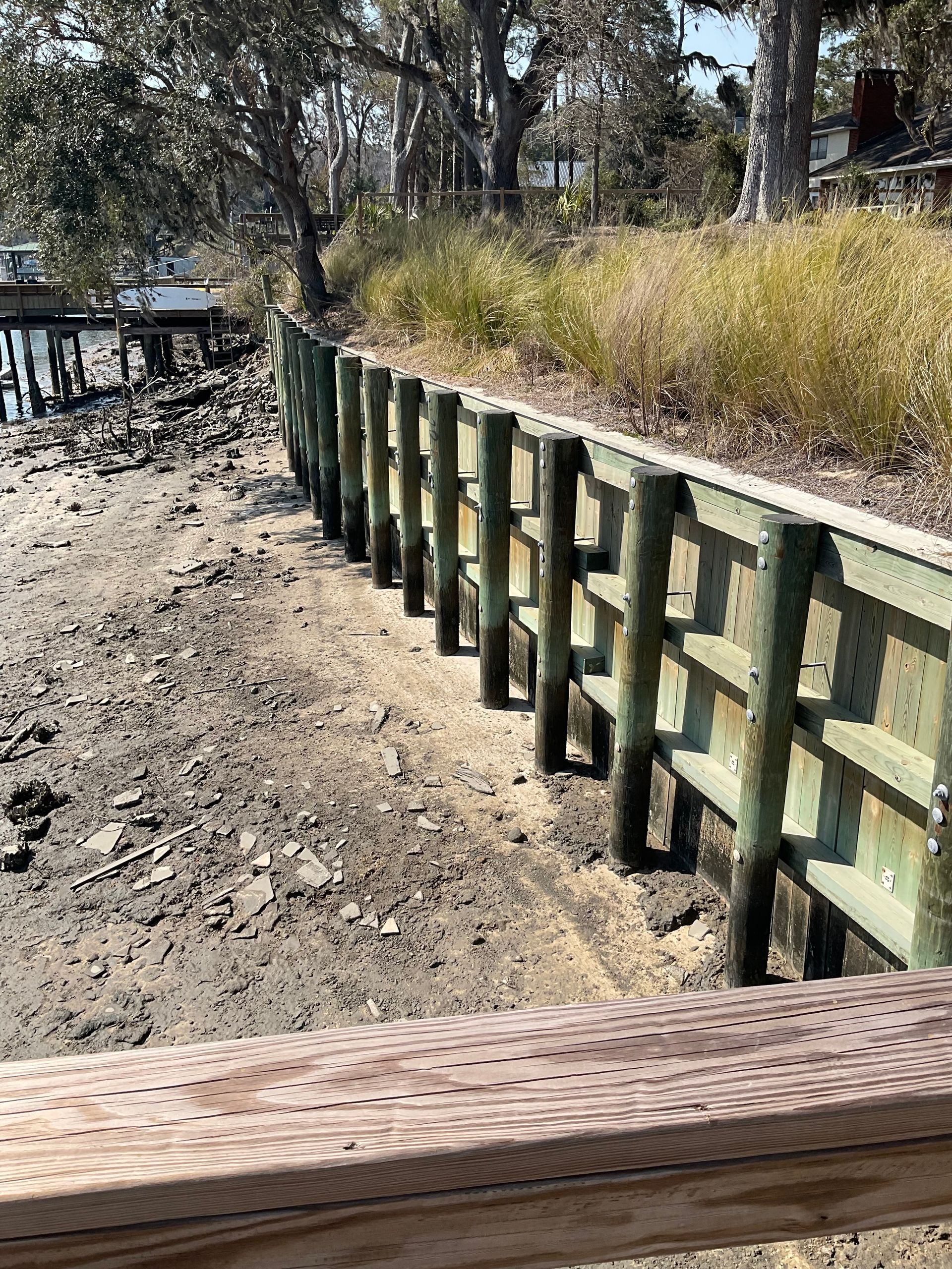 A wooden fence is sitting next to a body of water.