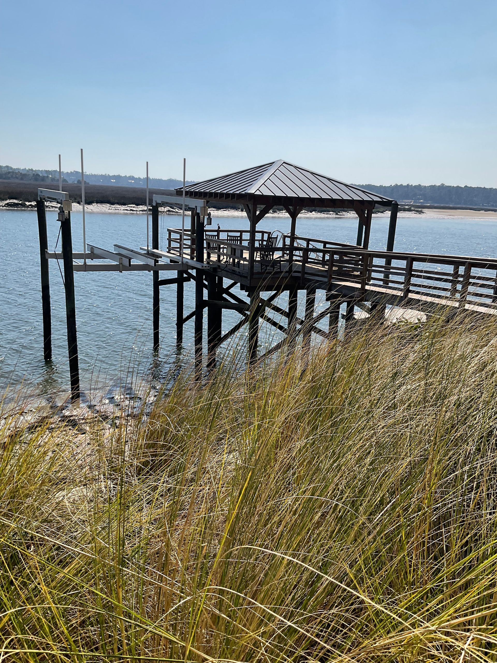 A dock with a gazebo on top of it overlooking a body of water.