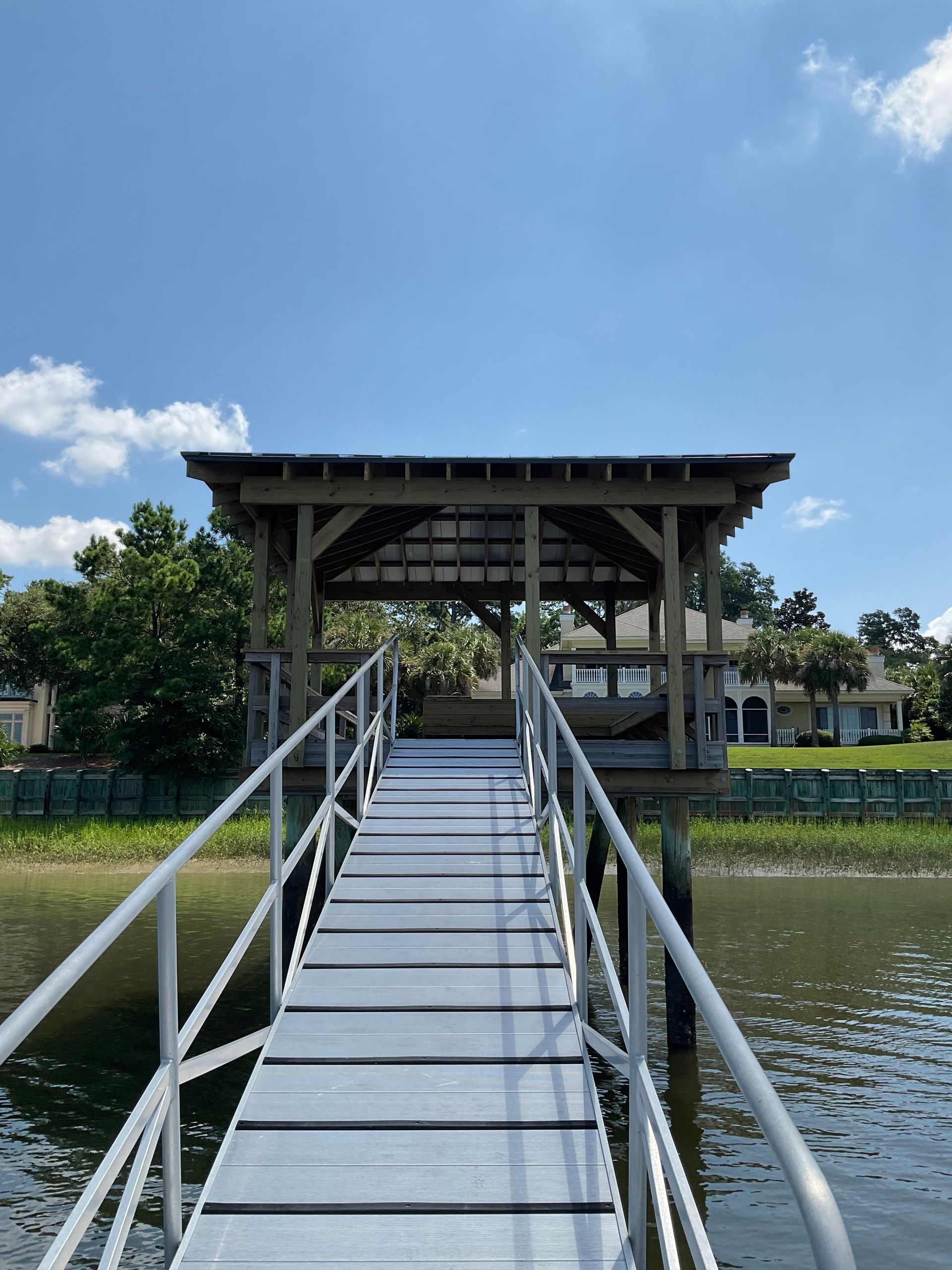 A dock with stairs leading to a building overlooking a body of water