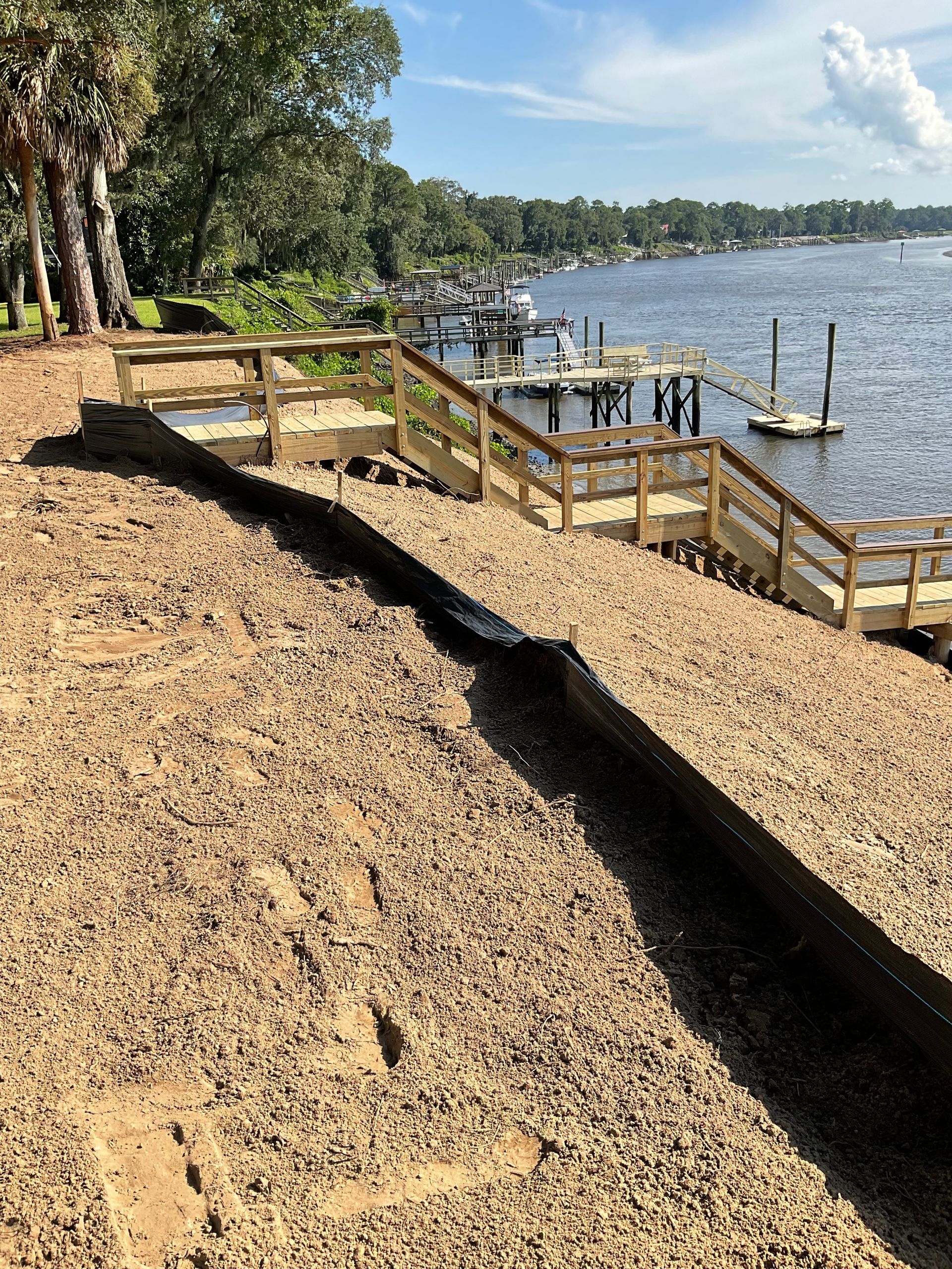 A wooden dock with stairs leading up to it next to a body of water.