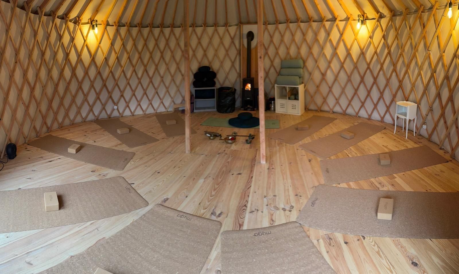 À l'intérieur d'une yourte avec plancher en bois, nattes et poêle à bois.