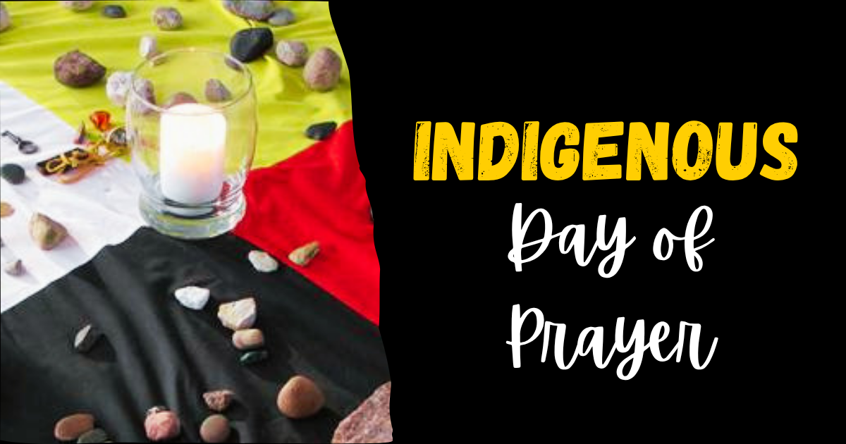 A tablecloth with a medicine wheel pattern holds a white candle and some scattered pebbles.