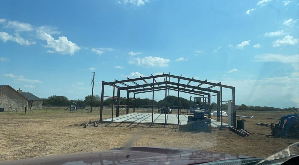A large metal structure is being built in a field.