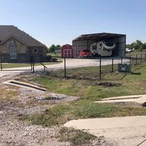 There is a house and a hangar in the background.