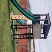 A playground with a slide and a climbing wall.
