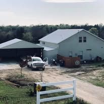 A white truck is parked in front of a large white house.