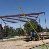 A truck is parked in front of a metal structure.