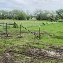 There is a fence in the middle of a grassy field.