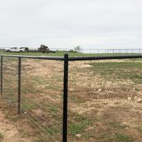 There is a fence in the middle of a field.