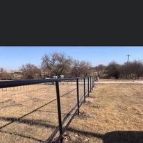 There is a fence in the middle of a field.