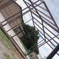 A greenhouse is being built in the backyard of a house.