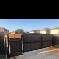 A wooden fence with a gate in the backyard of a house.