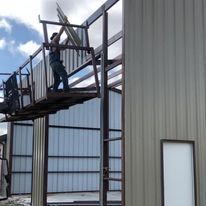 A man is standing on top of a metal structure.