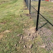 A fence is sitting in the middle of a grassy field.