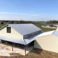 An aerial view of a barn with a metal roof.