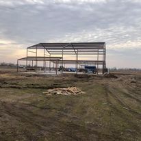 A large metal structure is being built in the middle of a field.