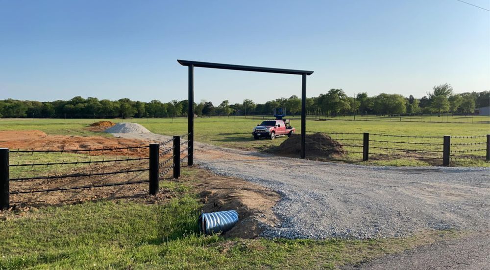 A truck is parked in a field next to a fence.