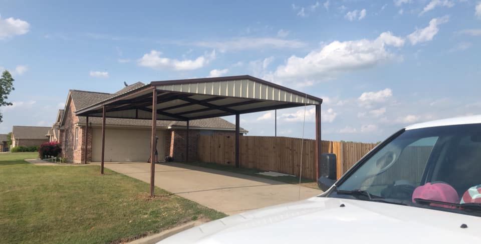 A car is parked under a carport in front of a house.