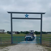 A car is driving through a gate with a star on top of it.