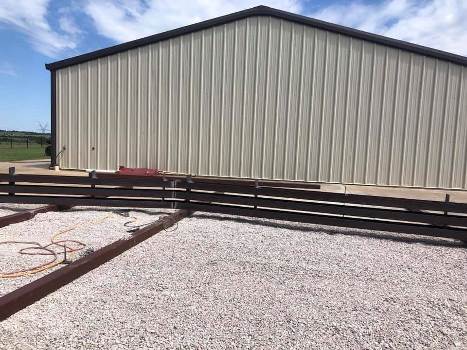A large white building with a wooden fence in front of it.