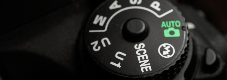 Close-up of a DSLR camera control dial showing various settings for manual, aperture, shutter, and a