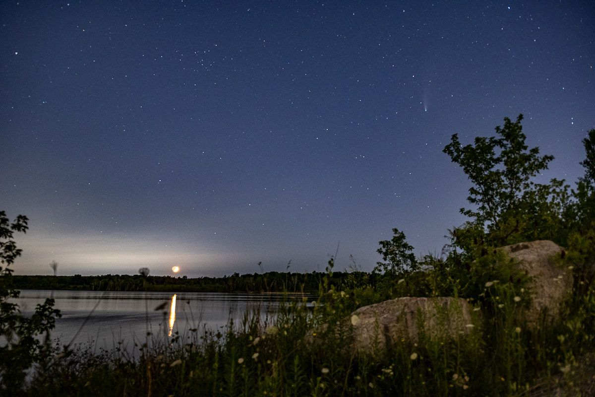 A lake at night with a lot of stars in the sky